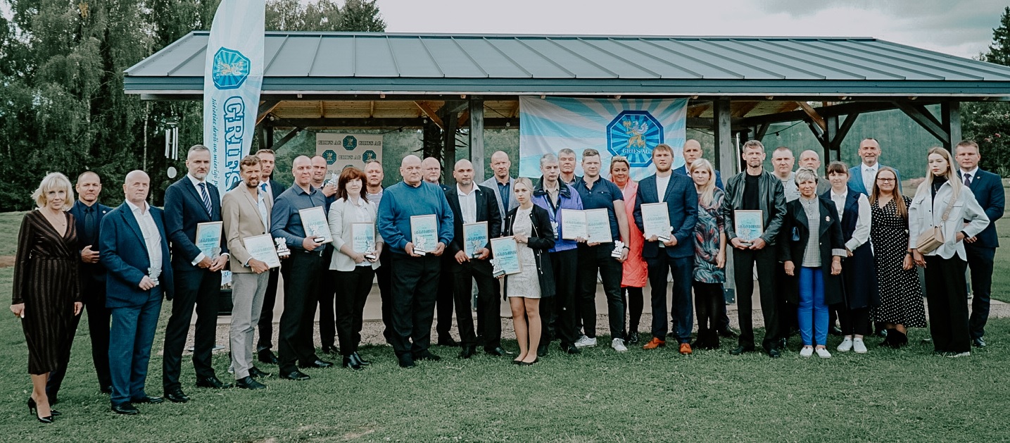 Cilvēku grupa stāv priekšā mājai